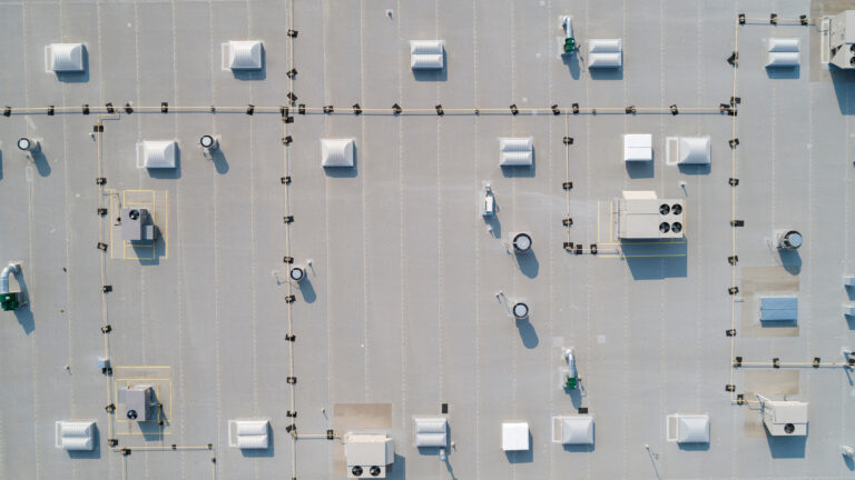 Aerial drone view of a commercial rooftop showing HVAC units and skylights